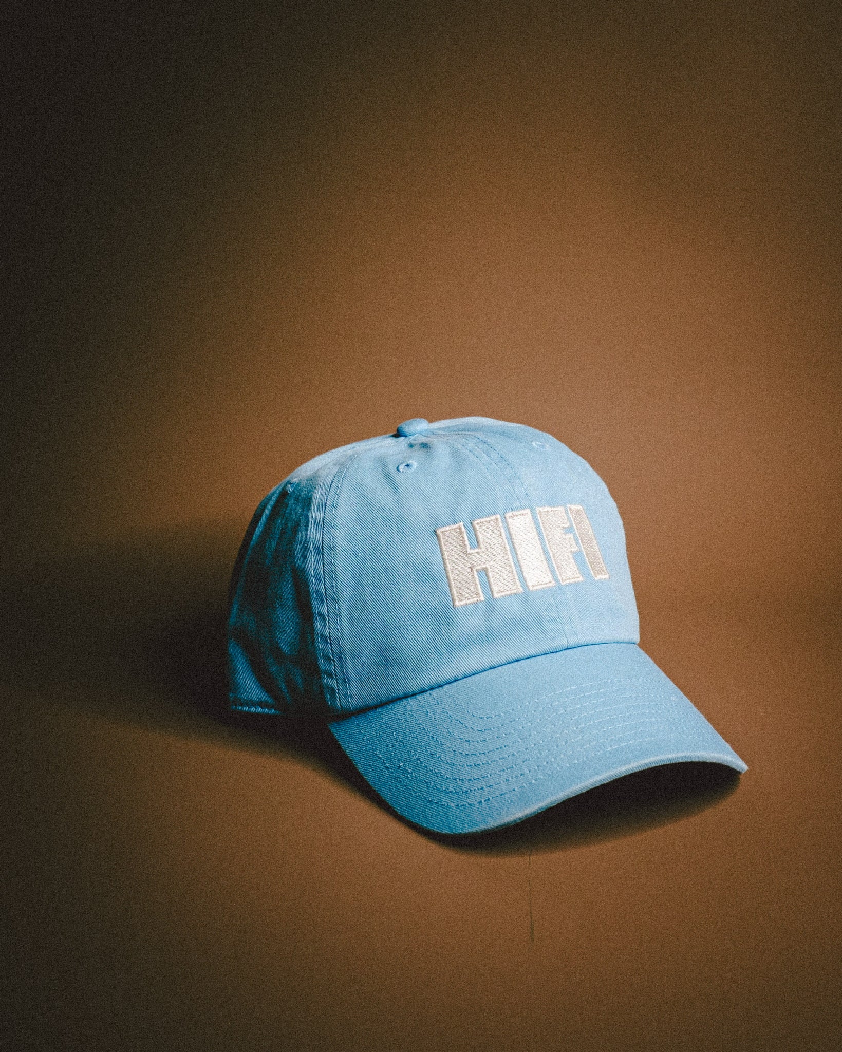 Blue cap with 'HIFI' text on a brown background