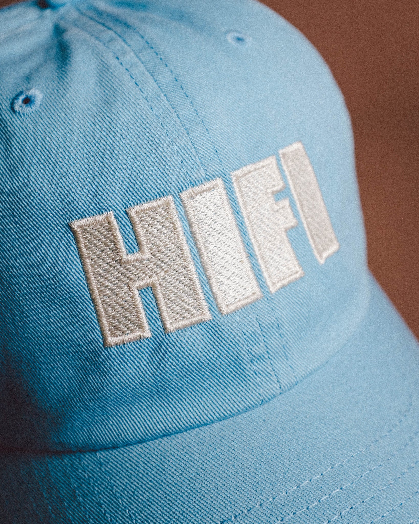 Light blue cap with 'HIFI' embroidery on a brown background