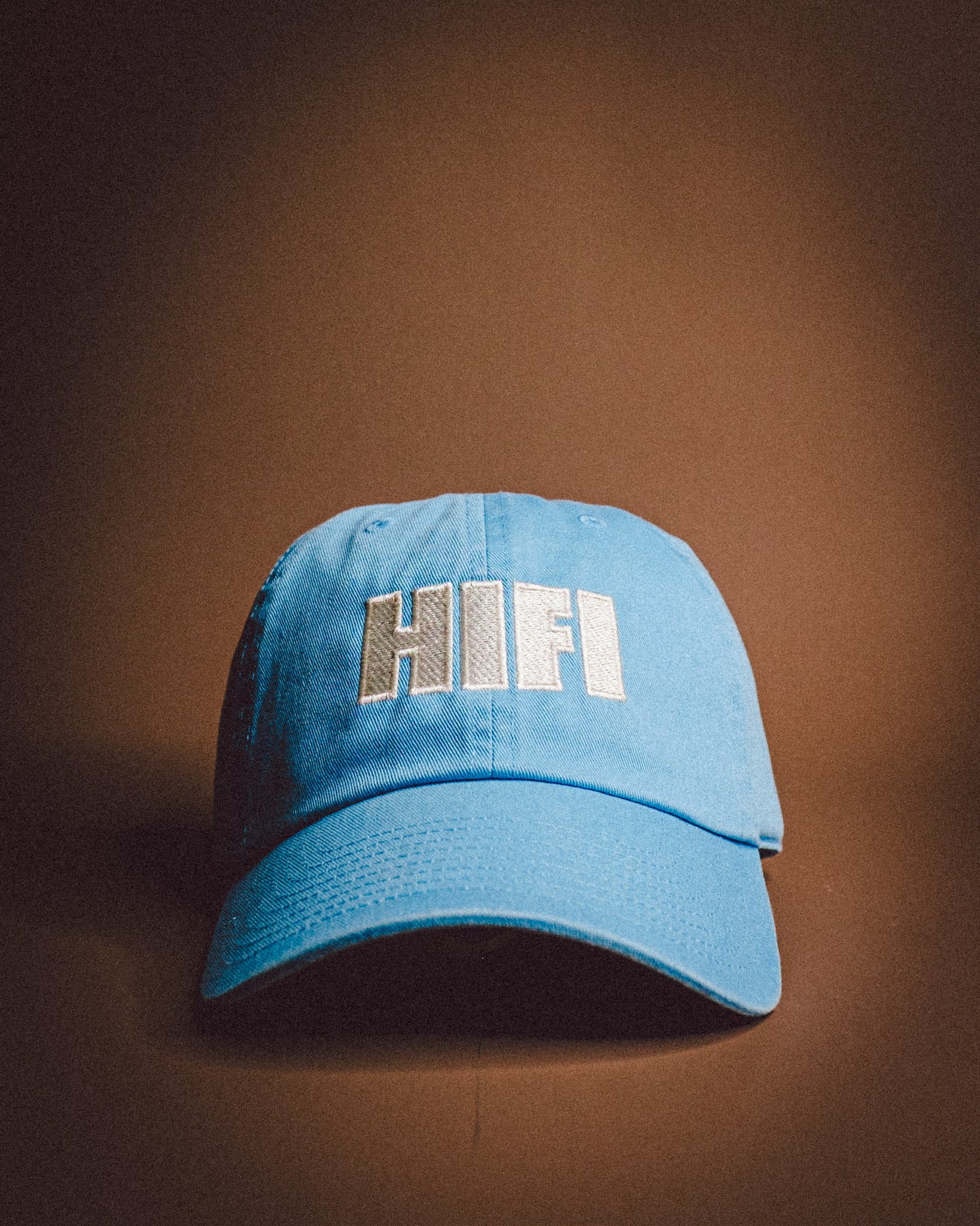 Blue cap with 'HIFI' text on a brown background