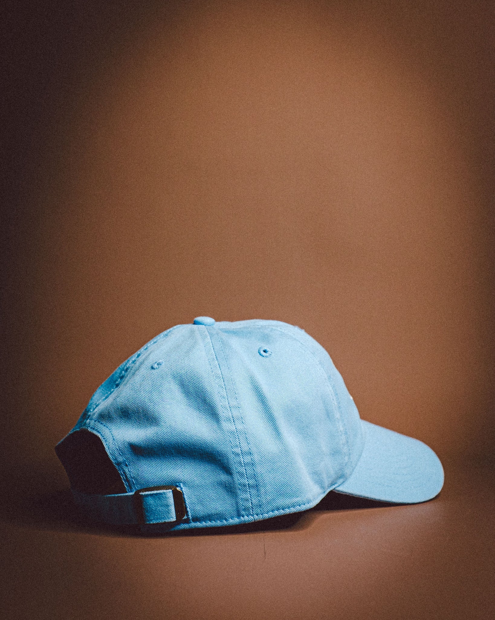 Blue baseball cap on a brown background